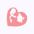 Mother raising a baby in heart shaped silhouette Royalty Free Stock Photo