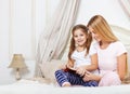 Mother reading bed time story book to her daughter Royalty Free Stock Photo