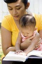 Mother reading book while babysitting