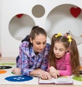 Mother reading book with her daughter at home Royalty Free Stock Photo