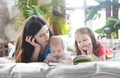 Mother reading a book with her daughter and son in bedroom Royalty Free Stock Photo