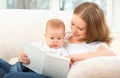 Mother reading a book a little baby on the sofa Royalty Free Stock Photo