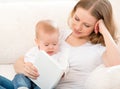 Mother reading a book a little baby on the sofa Royalty Free Stock Photo