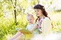 Mother reading book to baby outdoors Royalty Free Stock Photo