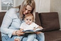 Mother reading a book to child boy indoors sitting on the couch Royalty Free Stock Photo