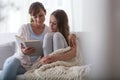 Mother reading book to daughter at home. Blurred foreground