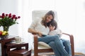Mother,reading a book to her child, sitting in rocking chair Royalty Free Stock Photo