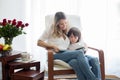 Mother,reading a book to her child, sitting in rocking chair Royalty Free Stock Photo