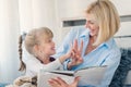 Mother reading a book to her young daughter at home Royalty Free Stock Photo