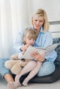 Mother reading a book to her young daughter at home Royalty Free Stock Photo