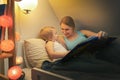 mother reading fairy tail book to her child in the evening before sleep Royalty Free Stock Photo