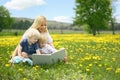 Mother Reading Story Book to Two Young Children Outside in Meadow Royalty Free Stock Photo