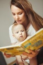 Mother reading to little infant colorful book with fairy tales. Royalty Free Stock Photo