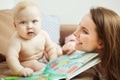 Mother reading to little infant colorful book with fairy tales. Royalty Free Stock Photo