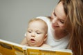 Mother reading to little infant colorful book with fairy tales. Royalty Free Stock Photo