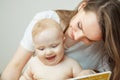 Mother reading to little infant colorful book with fairy tales. Royalty Free Stock Photo