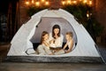 Mother reads a book of fairy tales for her children while sitting in a tent at night. Mom son and daughter reading a book Royalty Free Stock Photo