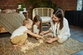 Mother reads a book of fairy tales for her children while sitting in a tent at night. Mom son and daughter reading a book with a Royalty Free Stock Photo