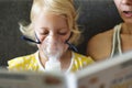 Baby girl making inhalation with mask on her face. Royalty Free Stock Photo