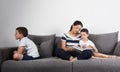 Mother reads an interesting book with her sons. Jealousy concept.