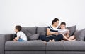 Mother reads an interesting book with her sons. Jealousy concept.
