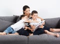 Mother reads an interesting book with her sons of the sofa. Royalty Free Stock Photo
