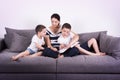 Mother reads an interesting book with her sons of the sofa. Royalty Free Stock Photo