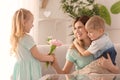 Mother receiving flowers from her cute little children at home Royalty Free Stock Photo