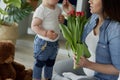 Mother receiving flowers from her toddler boy Royalty Free Stock Photo