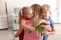 Mother receiving gift and flowers from her cute little children at home Royalty Free Stock Photo