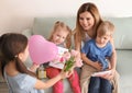 Mother receiving gifts from her cute little children at home Royalty Free Stock Photo