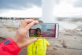 Mother recording video of her preschool son, boy enjoying the eruption of Strokkur Geysir in Iceland