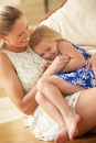 Mother Relaxing At Home With Daughter