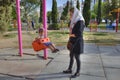 Mother rocking little boy on swing in park, Shiraz, Iran.