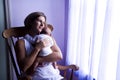 Mother rocking newborn baby by window Royalty Free Stock Photo