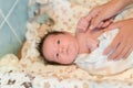 Mother rubs baby after bathing. the boy smiles and feels happy after taking a bath. mother dries and rubs the hair of the newborn Royalty Free Stock Photo