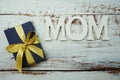 Mother`s day background with Mom alphabet letters Decoration with gift box on wooden background Royalty Free Stock Photo