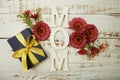 Mother`s day background with Mom alphabet letters and Flowers and gift box on wooden background Royalty Free Stock Photo