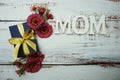 Mother`s day background with Mom alphabet letters and Flowers and gift box on wooden background Royalty Free Stock Photo