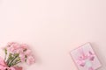 Mother`s day background. Top view of gift with carnation bouquet on pink table background