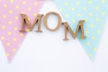 Mom wooden text on pastel fabric triangle flag on white paper texture background