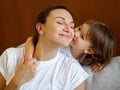 Mother's Day Concept. Cute Little Girl Kissing Her Mom In Cheek Royalty Free Stock Photo
