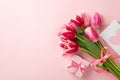 Top view photo of bunch of pink tulips tied with ribbon small giftbox with bow and envelope with postcard Royalty Free Stock Photo