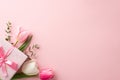 Top view photo of stylish pink giftbox with ribbon bow and bouquet of tulips on isolated pastel pink background Royalty Free Stock Photo