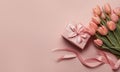 Mother\'s Day concept. Top view photo of stylish pink giftbox with ribbon bow and bouquet of tulips on isolated pastel pink Royalty Free Stock Photo