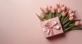 Mother\'s Day concept. Top view photo of stylish pink giftbox with ribbon bow and bouquet of tulips on isolated pastel pink Royalty Free Stock Photo