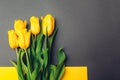 Mother's day flowers. Bouquet of yellow tulips on grey background. Present, gift for spring holiday. Space Royalty Free Stock Photo