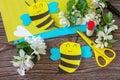 Mother`s day greeting card gift - bee with spring apple tree flowers on a wooden table. Childrens creativity project, handmade,