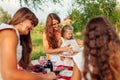 Mother`s day, Women`s day. Woman and her kids with grandmother reading books. Family having picnic in park Royalty Free Stock Photo
