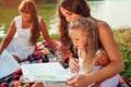 Mother`s day, Women`s day. Woman and her kids with grandmother reading books. Family having picnic in park Royalty Free Stock Photo